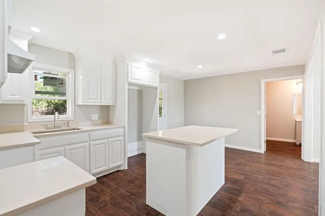 a kitchen with granite countertop a sink stove and refrigerator