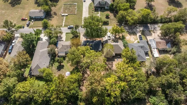an aerial view of residential house with outdoor space and trees all around