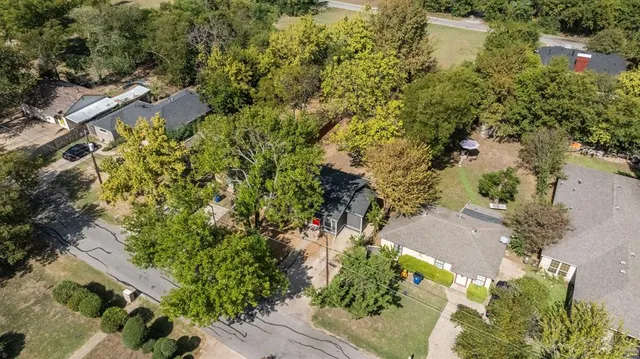 an aerial view of residential house with outdoor space and trees all around