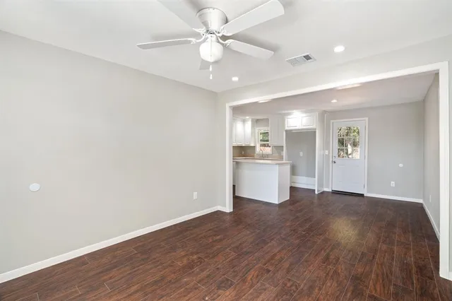 a view of a kitchen with wooden floor and a kitchen space with a sink
