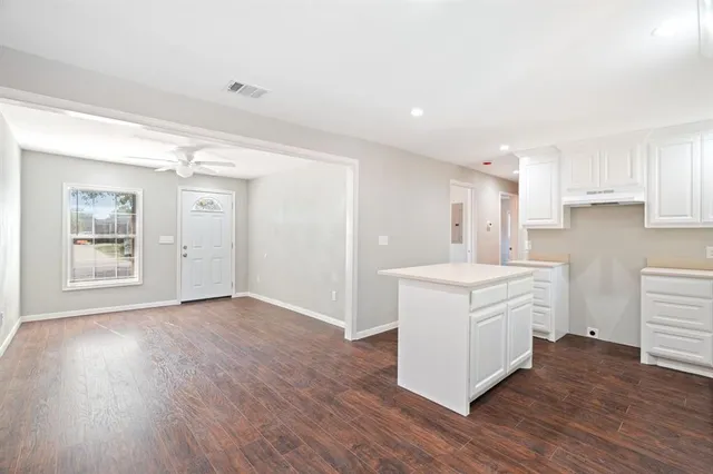 a kitchen with stainless steel appliances a white stove top oven cabinets and wooden floor