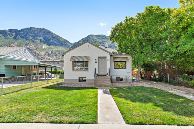 372 800 East Provo, UT 84606 - Photo 2 of 29 Stucco exterior residence featuring a front lawn, concrete pathway, and mature shade tree