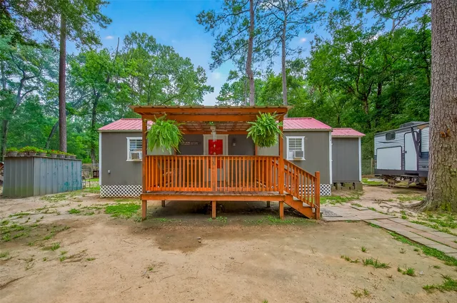 a view of a small house in a yard with wooden fence