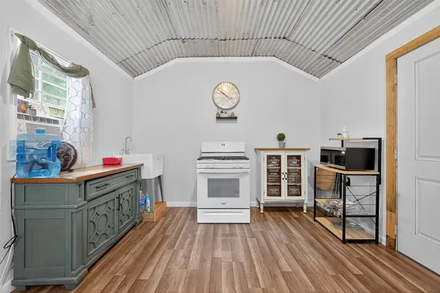 a view of a livingroom with wooden floor and a bathroom