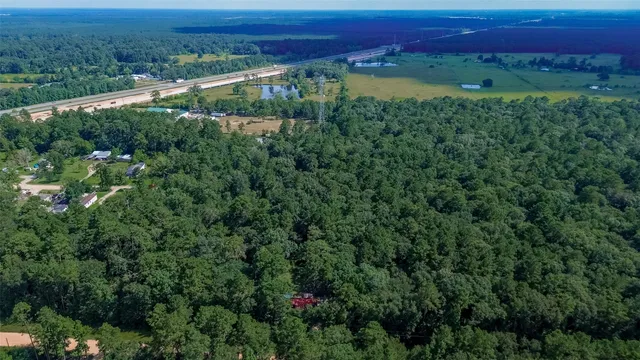 an aerial view of a houses with a lush green forest