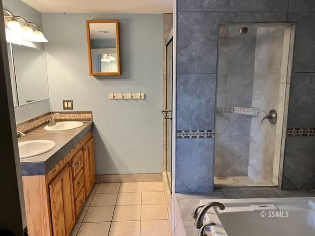 305 South Silver Ridge Street Ridgecrest, CA 93555 - Photo 13 of 32 a bathroom with a granite countertop sink a mirror and a shower
