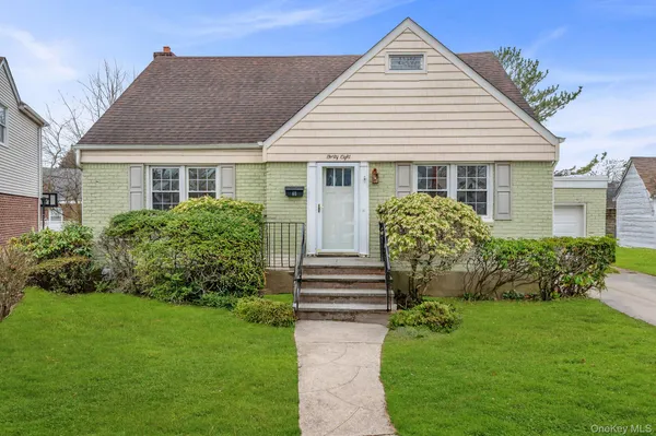 a front view of a house with a garden