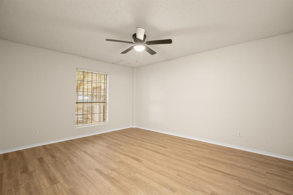2401 Leon Street, Unit 105 Austin, TX 78705 - Photo 12 of 18 an empty room with wooden floor fan and windows