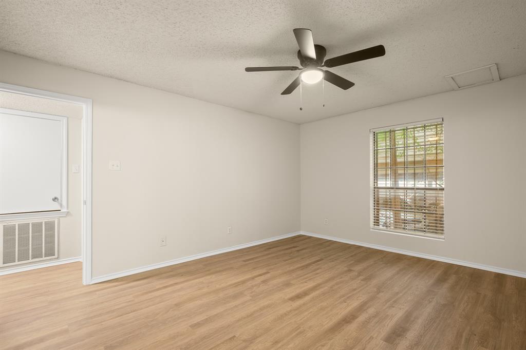 2401 Leon Street, Unit 105 Austin, TX 78705 - Photo 13 of 18 a view of an empty room with wooden floor and a window