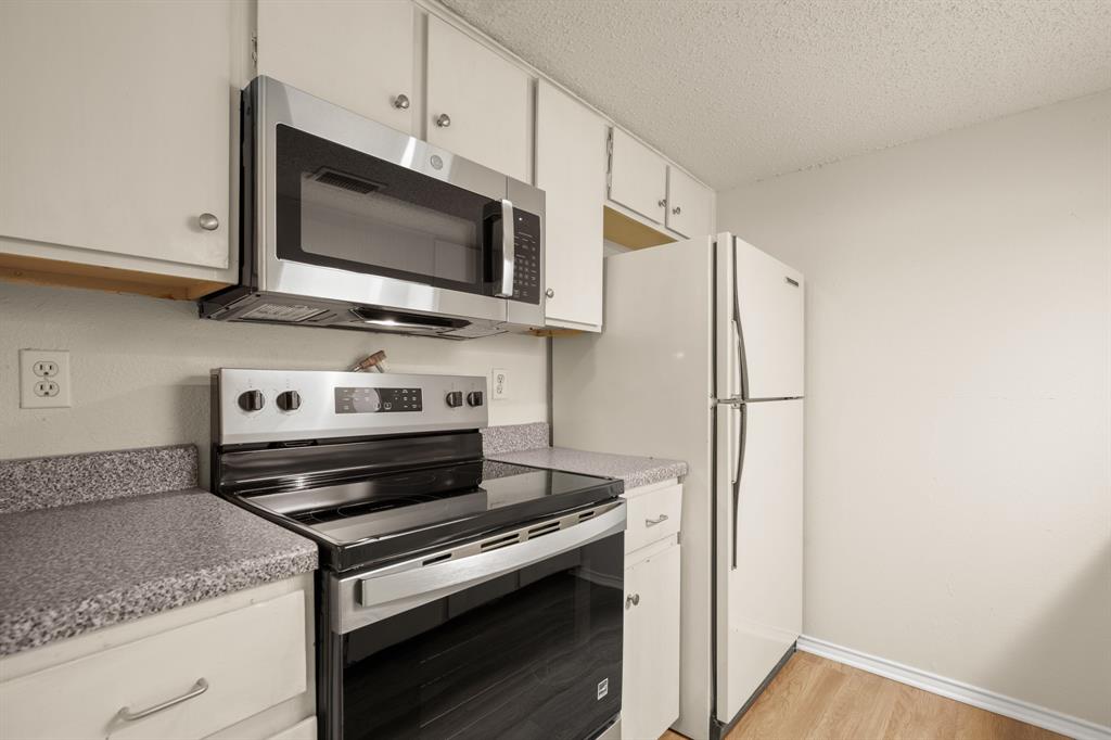 2401 Leon Street, Unit 105 Austin, TX 78705 - Photo 6 of 18 a kitchen with a stove and a microwave