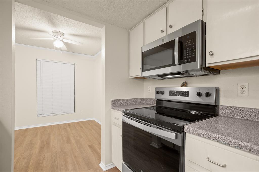 2401 Leon Street, Unit 105 Austin, TX 78705 - Photo 8 of 18 a kitchen with stainless steel appliances granite countertop a stove and a microwave