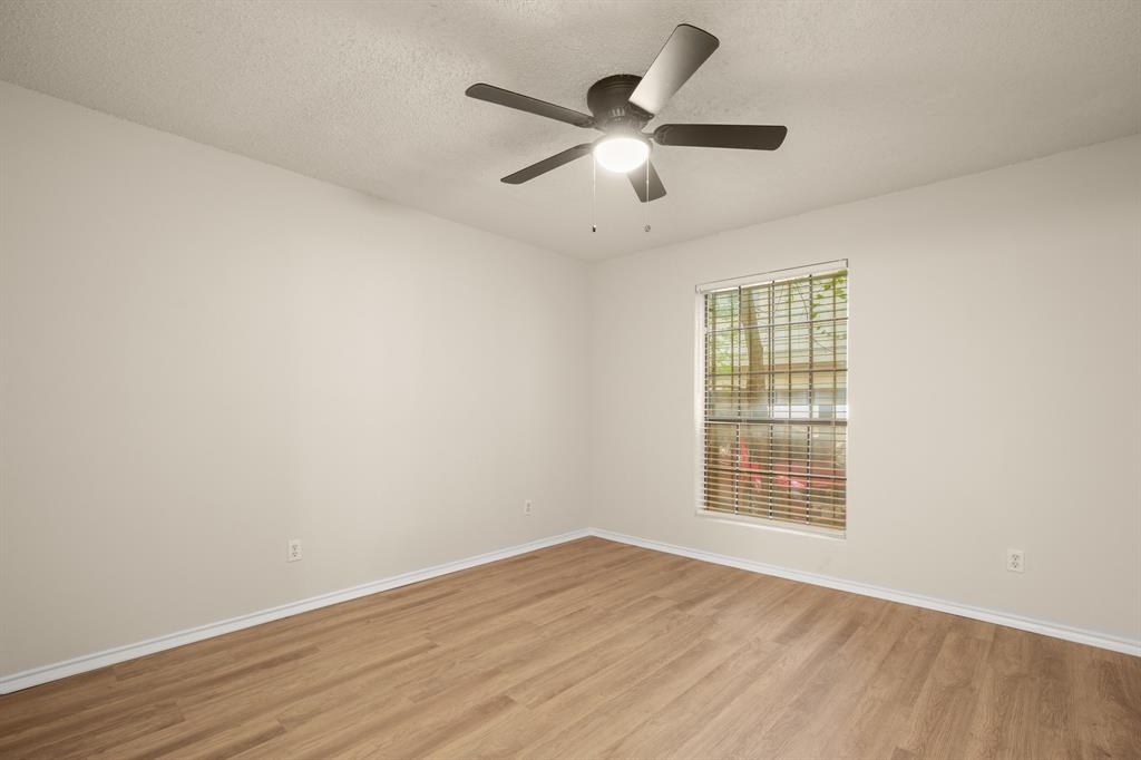 2401 Leon Street, Unit 105 Austin, TX 78705 - Photo 10 of 18 an empty room with wooden floor ceiling fan and windows