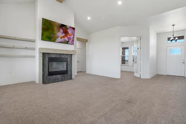 an empty room with windows and fan