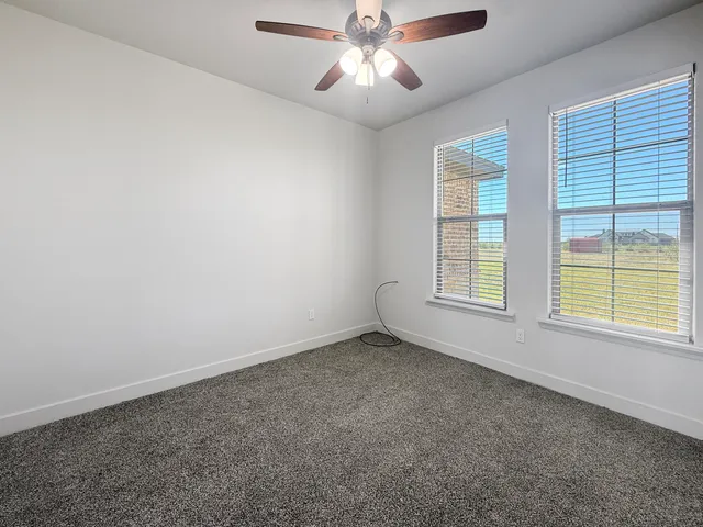 a view of an empty room with a fireplace and a window