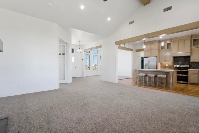 an empty room with chandelier and windows