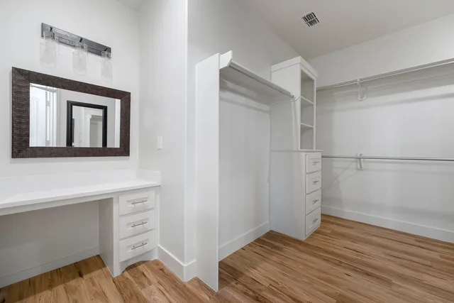 a view of walk in closet with empty racks