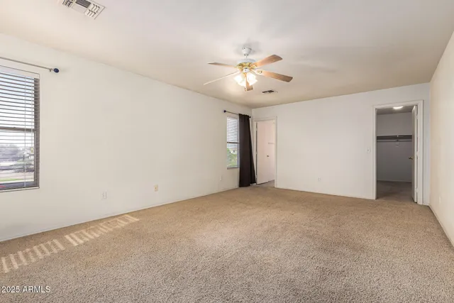 an empty room with closet and windows