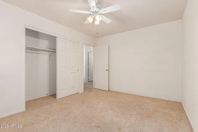 a view of a livingroom with a ceiling fan and window
