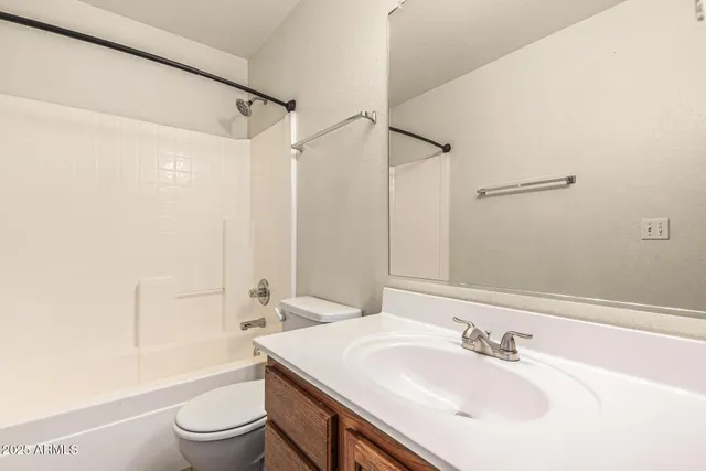 a view of an empty room with chandelier fan