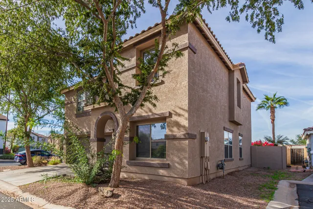 a front view of a house with a tree