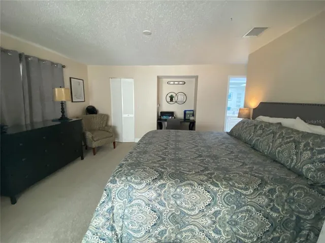 a bedroom with a bed and dresser with mirror