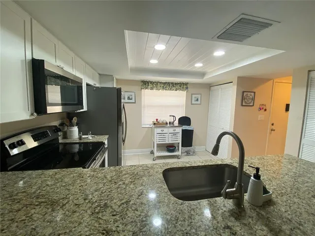 a kitchen with granite countertop a stove and a sink