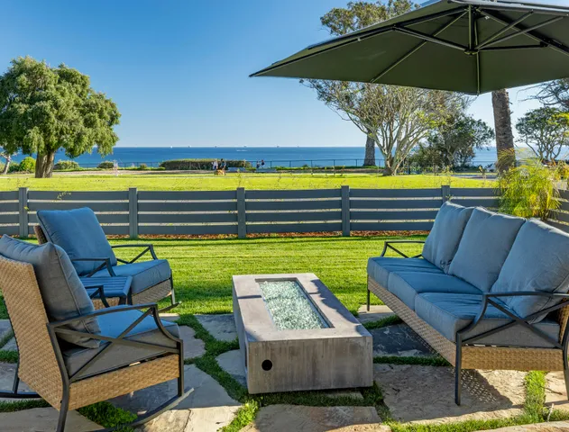 a view of a chairs and table in the back yard