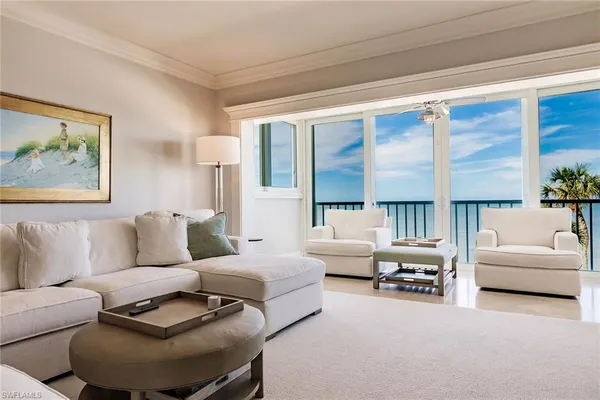 a living room with furniture and a large window with balcony view