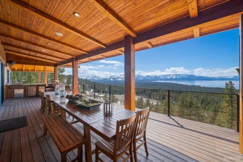 a view of a balcony with wooden floor and outdoor seating