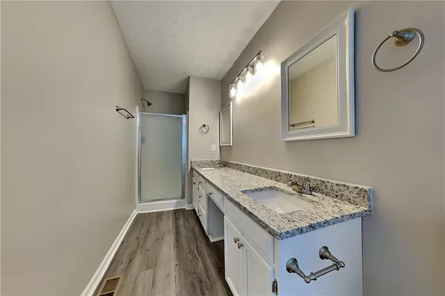 a hallway with granite countertop a sink and dishwasher with wooden floor