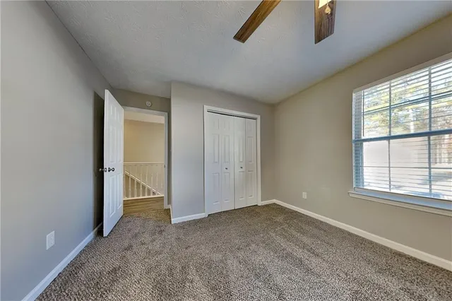 an empty room with windows and closet