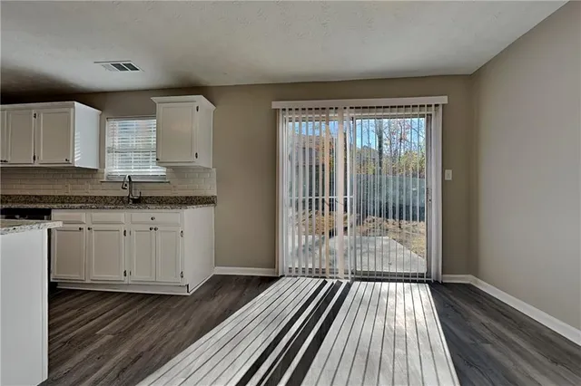 a view of a kitchen with wooden floor and electronic appliances