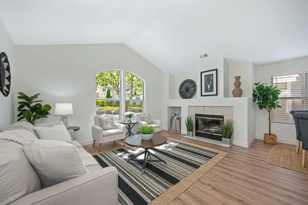a living room with furniture a fireplace and a floor to ceiling window