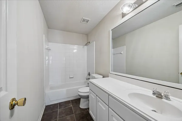 a bathroom with a granite countertop sink a toilet and shower