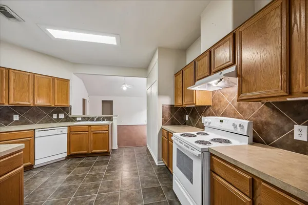 a kitchen with stainless steel appliances granite countertop a stove a sink and a refrigerator