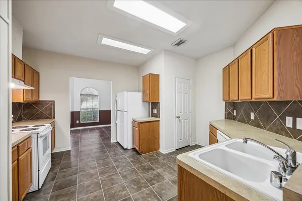 a kitchen with a sink stove and refrigerator