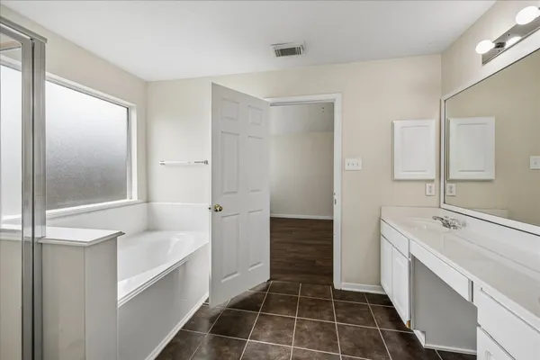 a bathroom with a tub sink and shower