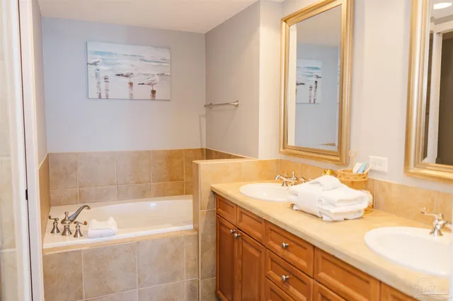 a bathroom with a granite countertop sink a mirror and a bathtub