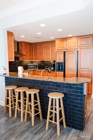 a large kitchen with stainless steel appliances granite countertop a stove refrigerator sink and cabinets
