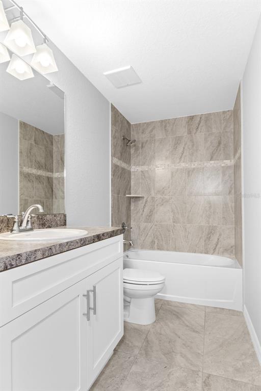 16375 Kakawi Road Brooksville, FL 34614 - Photo 25 of 30 a bathroom with a granite countertop sink a toilet and bathtub