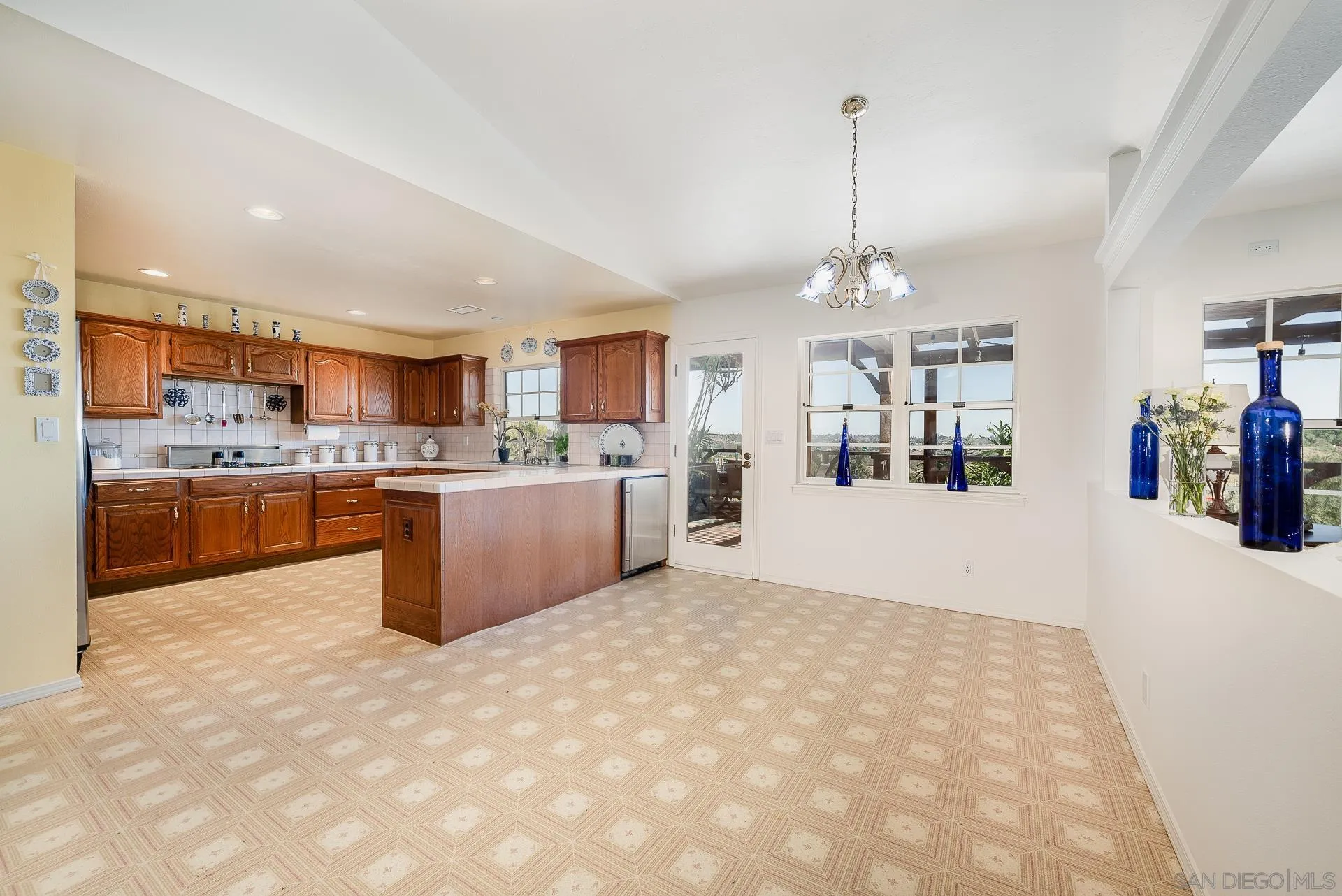 4241 Via El Dorado Fallbrook, CA 92028 - Photo 22 of 64 a large kitchen with kitchen island a stove a refrigerator a oven a dining table and chairs