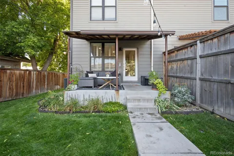 a view of a chair and table in backyard of the house