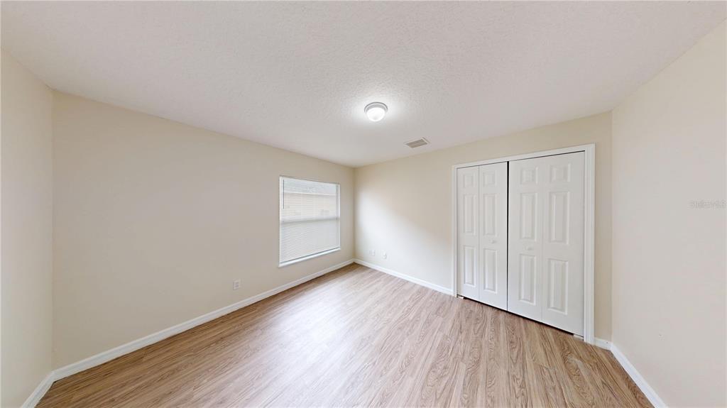 3209 Murray Hill Loop Kissimmee, FL 34758 - Photo 13 of 23 an empty room with wooden floor and windows