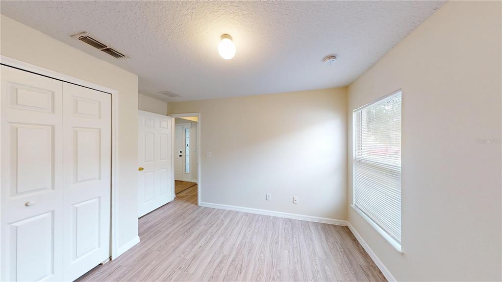 3209 Murray Hill Loop Kissimmee, FL 34758 - Photo 8 of 23 an empty room with wooden floor and windows