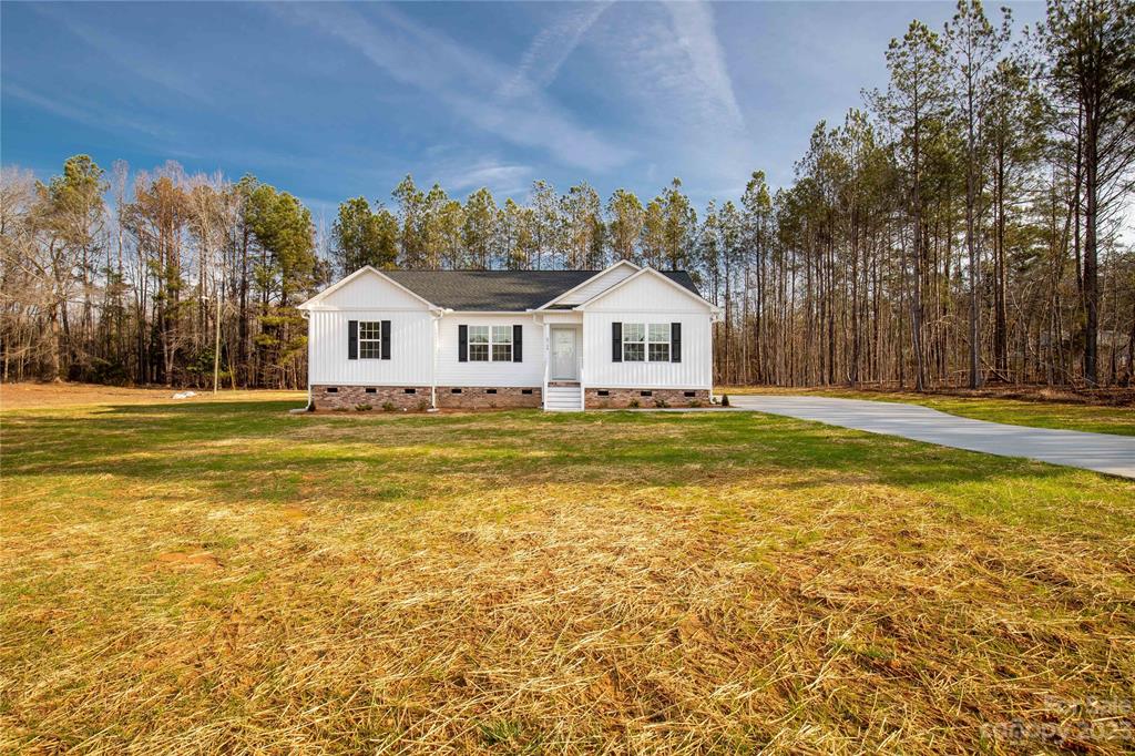 6724 State Rd S-29-555 Kershaw, SC 29067 - Photo 3 of 31 a front view of a house with a garden and a tree