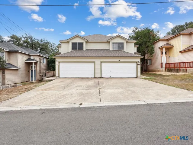 a white house with a large tree in front of it