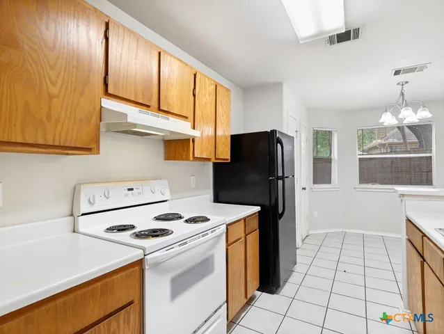 a kitchen with a stove a refrigerator and a cabinets
