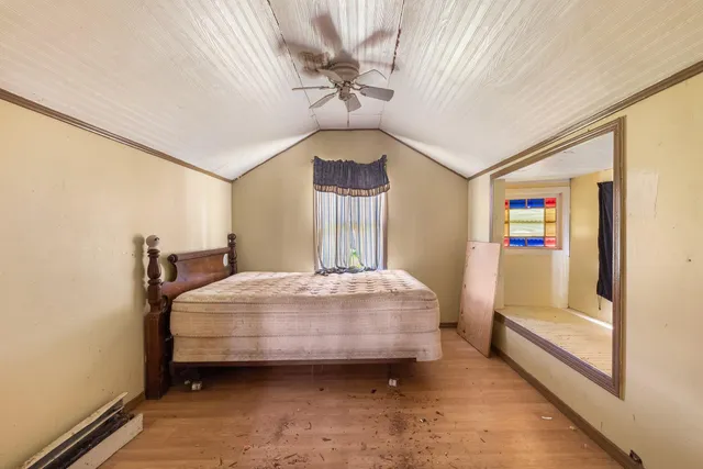 a bedroom with a bed dresser and a window