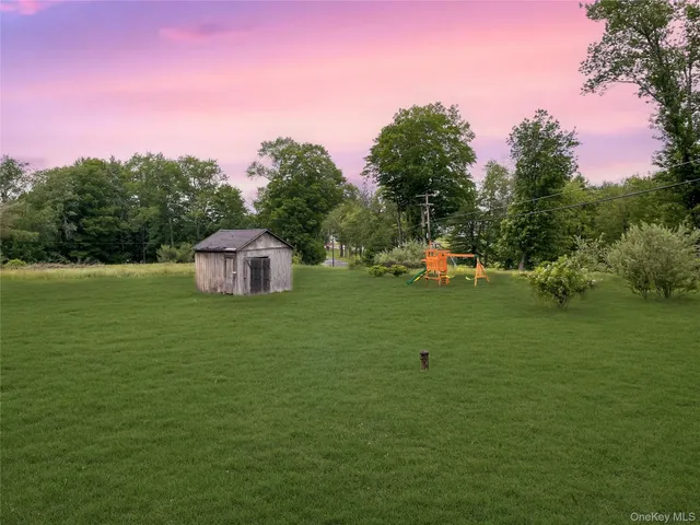 a front view of a house with a garden and trees
