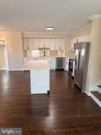 a kitchen with stainless steel appliances granite countertop a refrigerator a sink dishwasher a stove and a refrigerator with wooden floor